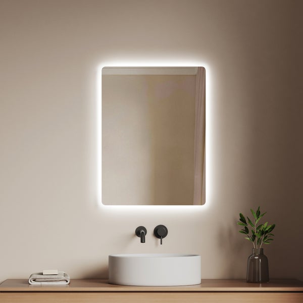 Badezimmer mit beleuchtetem Spiegel, Waschbecken und Armaturen