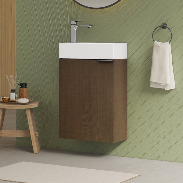 Waschtisch mit Waschtischunterschrank, Armatur, Handtuchring und Dekoration auf einem Hocker