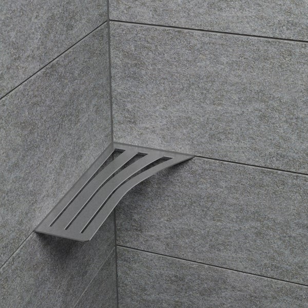 Eck-Duschablage aus Edelstahl im Lamellen-Design, montiert in der Fliesenfuge einer Dusche mit Fliesen in Steinoptik.