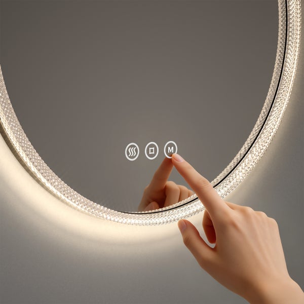 Nahaufnahme eines Spiegels mit runder Form und einem darauf zeigenden Finger, der einen der Touchscreen-Knöpfe bedient.