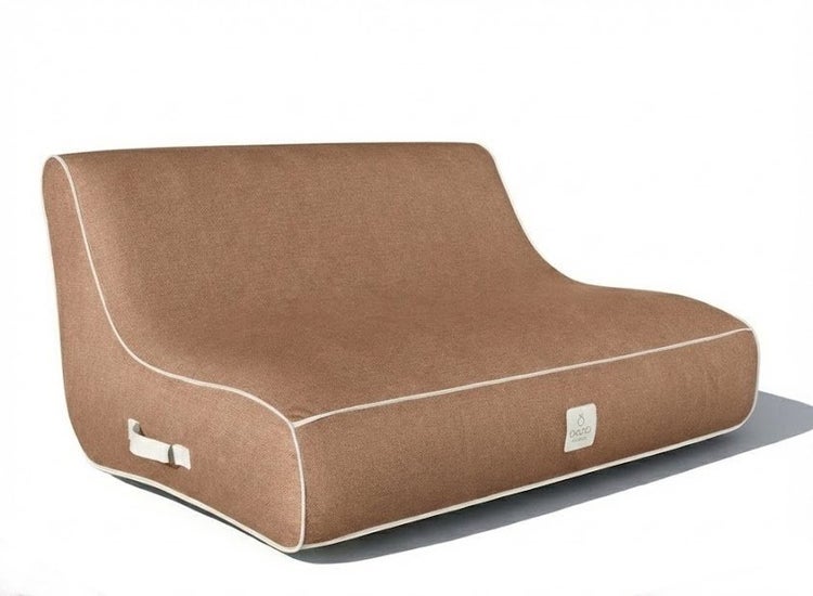 Braunes Sitzsack-Sofa aus strukturiertem Stoff mit weißer Paspelierung, Tragegriff und OUTbag Logo.