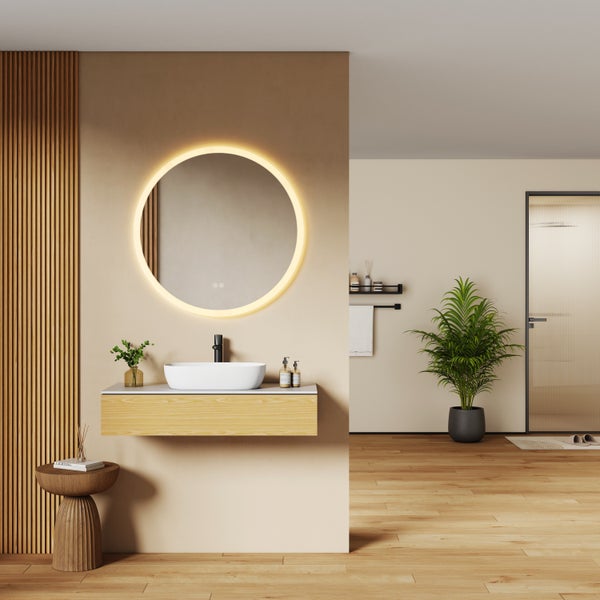 Modernes Badezimmer mit rundem LED-Spiegel, weißem Aufsatzwaschbecken auf einem Holzunterschrank und schwarzer Armatur.