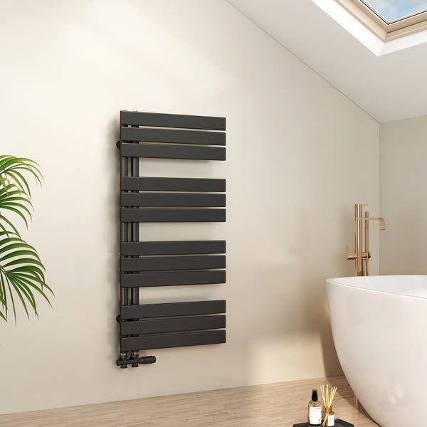 Designer Handtuchheizkörper in Schwarz in einem hellen Badezimmer mit freistehender Badewanne und goldener Armatur.