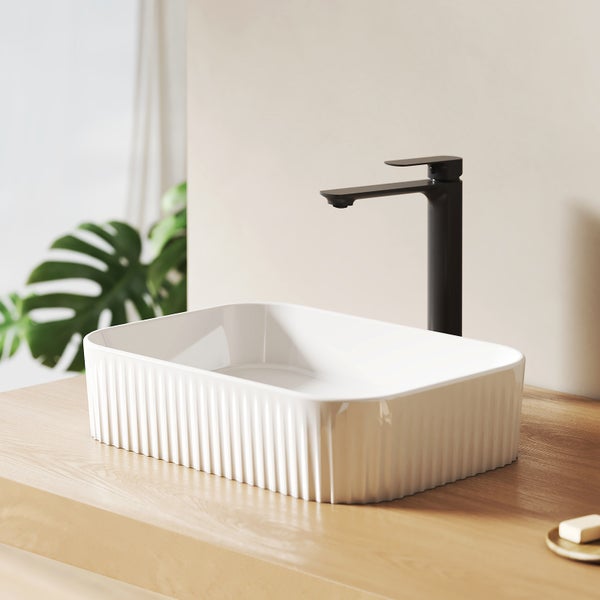 Rechteckiges Aufsatzwaschbecken aus Keramik mit geriffelter Oberfläche und schwarzer Armatur