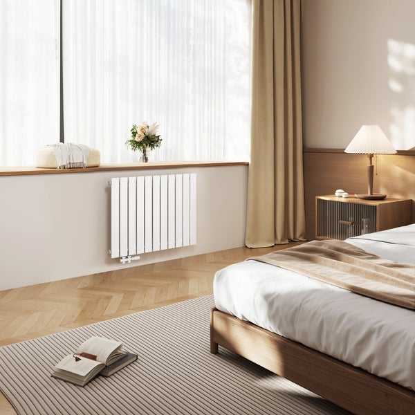 Schlafzimmer mit Heizkörper, Bett und Nachttisch