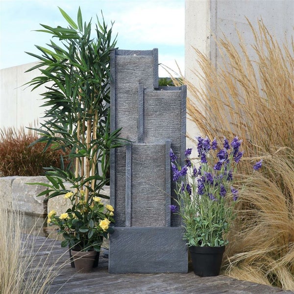 Mehrstufiger Gartenbrunnen aus Stein mit Bepflanzung