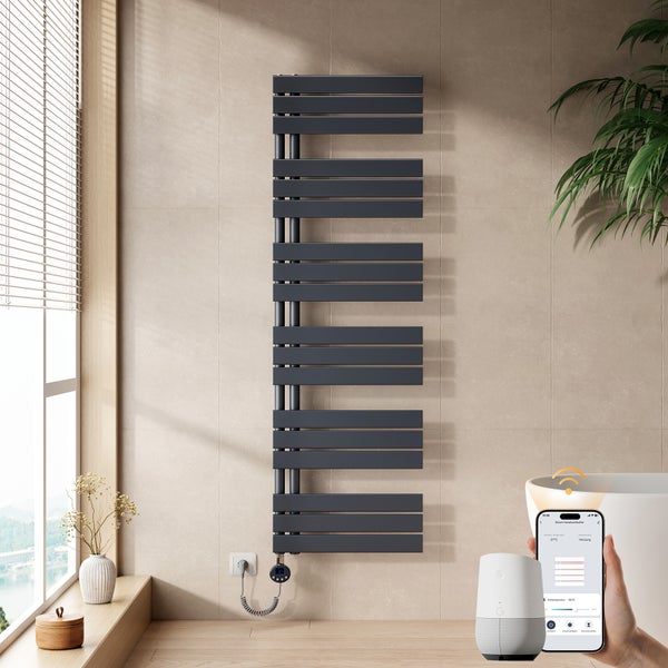 Moderner anthrazitfarbener Handtuchheizkörper an einer hellen Wand, gesteuert über eine App auf einem Smartphone und einen Smart-Home-Lautsprecher.