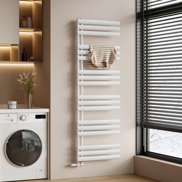 Moderner Badheizkörper an einer Wand neben einer Waschmaschine in einem hellen Badezimmer mit Fenster.