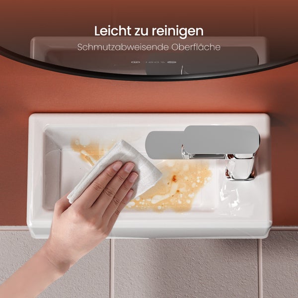 Hand reinigt ein Waschbecken mit einer schmutzabweisenden Oberfläche