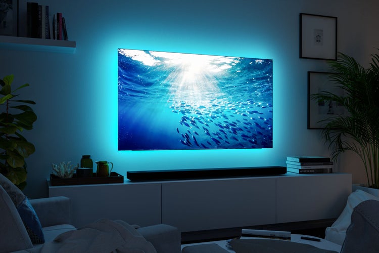 Modernes Wohnzimmer mit Fernseher, der Unterwasserszene und bläuliche Hintergrundbeleuchtung zeigt