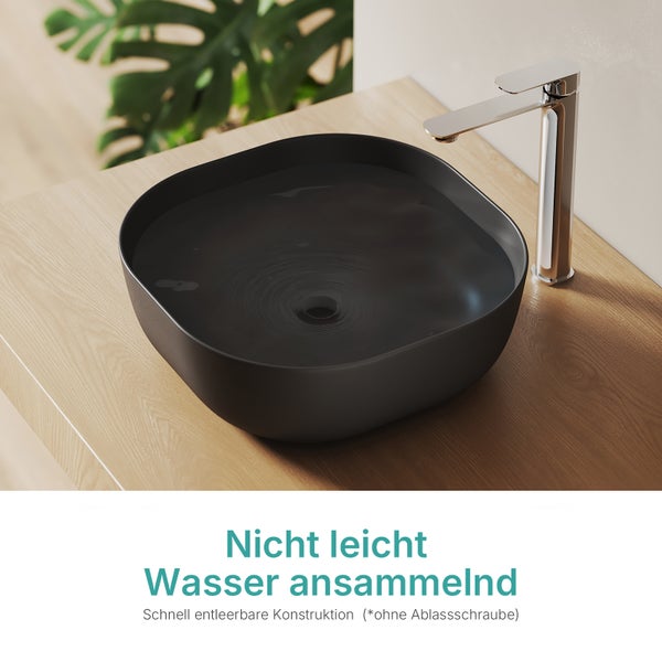 Schwarzes Aufsatzwaschbecken aus Keramik mit Armatur auf einem Holztisch