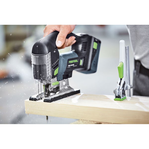Eine Person benutzt eine akkubetriebene Festool Stichsäge zum Sägen eines Holzbalkens, der mit einer Schraubzwinge fixiert ist.