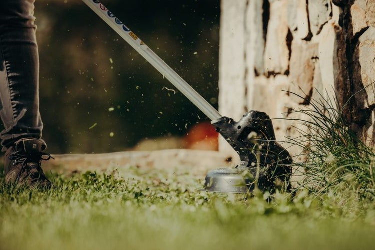 Gartenszene mit Rasentrimmer in Aktion