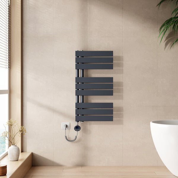 Elektrischer Badheizkörper mit horizontalen Paneelen an einer gefliesten Wand in einem modern eingerichteten Badezimmer.