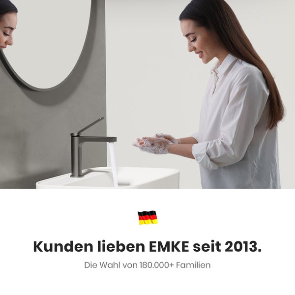 Frau wäscht sich die Hände am Waschbecken mit Armatur vor Spiegel