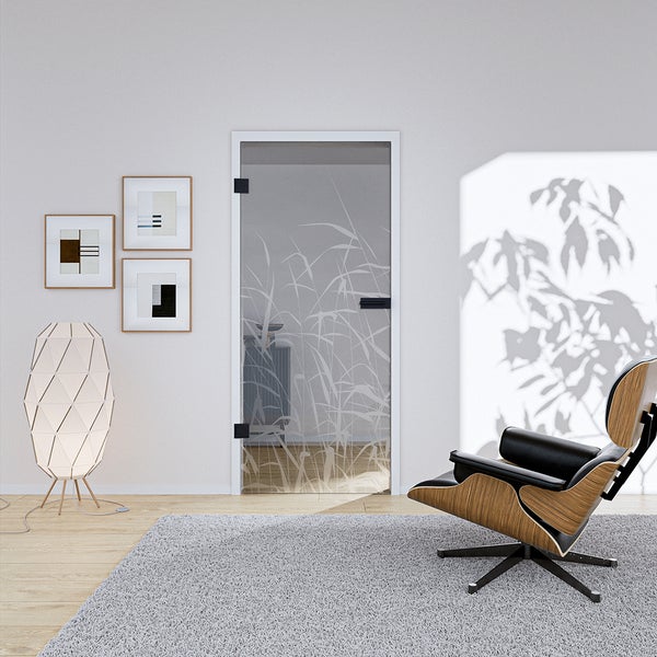 Ganzglastür mit Schilf-Motiv in einem modernen Wohnzimmer mit Design-Sessel aus Holz und Leder, Stehleuchte und Teppich.