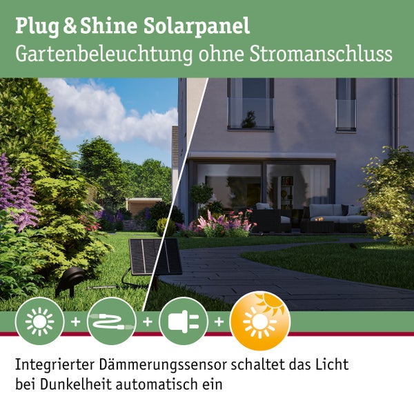 Moderner Garten mit Solarpanel und Gartenstrahler neben einem Steinweg, im Hintergrund eine Terrasse mit Lounge-Möbeln und ein Wohnhaus.