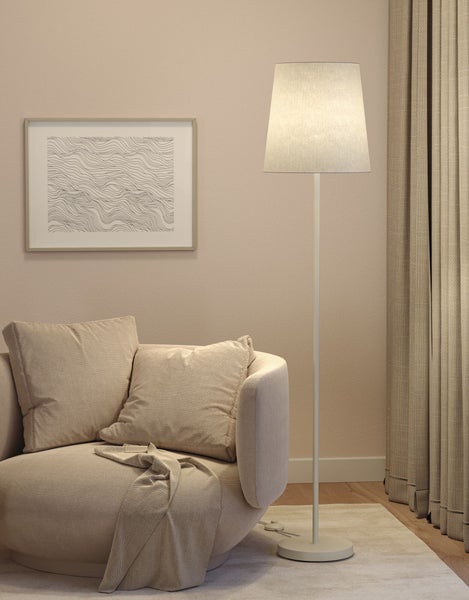 Wohnzimmer mit Sofa, Stehlampe und gerahmtem Bild an der Wand