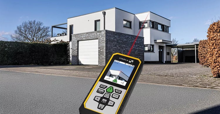 Laser-Entfernungsmesser bei der Messung eines Hauses