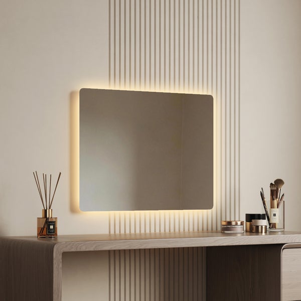 Rechteckiger Wandspiegel mit integrierter LED Beleuchtung über einem Holztisch mit Badezimmeraccessoires in einer modernen Einrichtung.