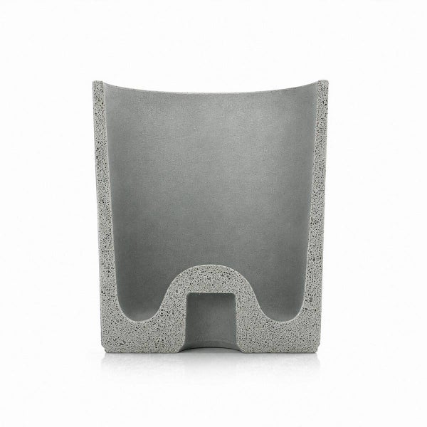 Ein moderner Pflanztopf aus Beton mit einer charakteristischen geschwungenen Bodenform für den Innen- und Außenbereich.