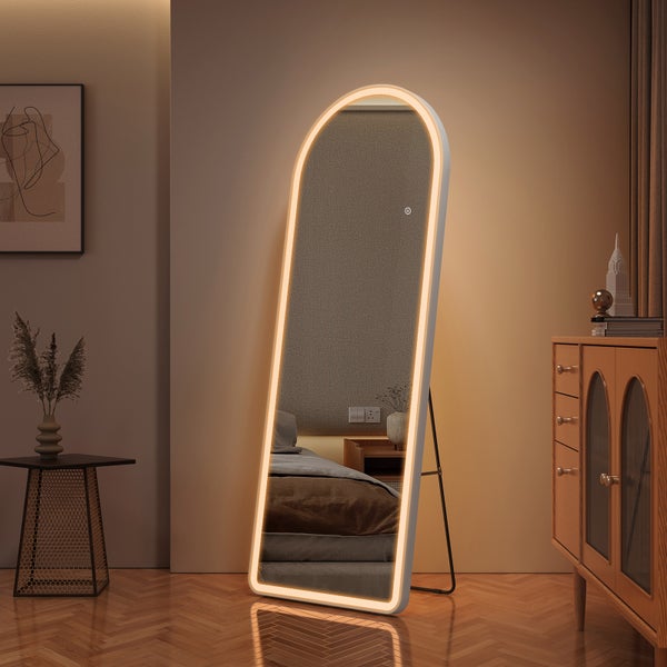 Bogenförmiger Standspiegel mit LED-Beleuchtung und Touch-Sensor in einem organisierten Schlafzimmer mit Parkettboden.