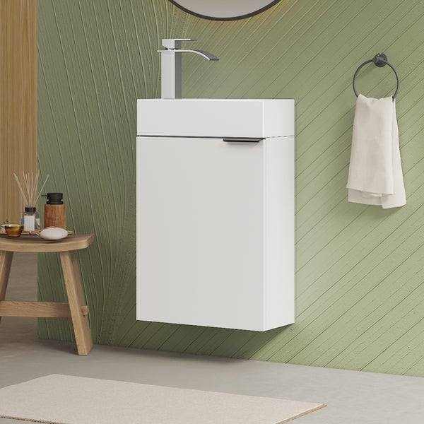 Hängender Waschtischunterschrank mit Waschbecken und Armatur in einem modern gestalteten Badezimmer mit Handtuchhalter an der Wand.