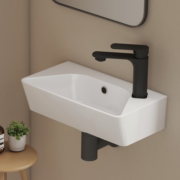 Wandhängendes, rechteckiges Waschbecken aus Keramik mit schwarzer Armatur und schwarzem Siphon in einem modernen Badezimmer.