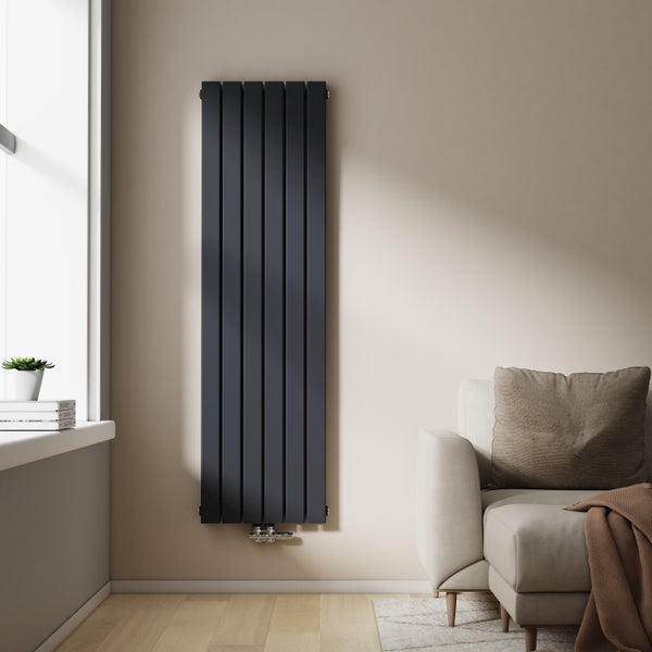 Vertikaler Heizkörper an der Wand in einem Wohnzimmer mit Sofa