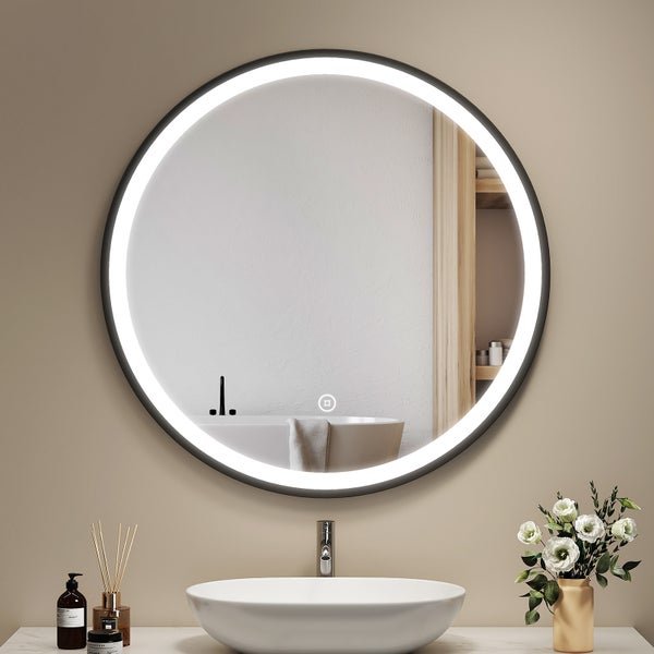 Runder LED Badezimmerspiegel mit Beleuchtung und schwarzem Rahmen über einem Aufsatzwaschbecken in einem modernen Badezimmer.