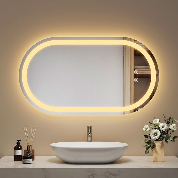 Ovaler Badezimmerspiegel mit integrierter LED Beleuchtung und Touch Steuerung über dem Waschbecken mit Armatur auf einem Waschtisch.