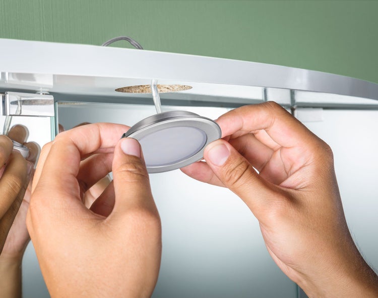 Installation einer Badezimmerlampe unter einem Spiegelschrank