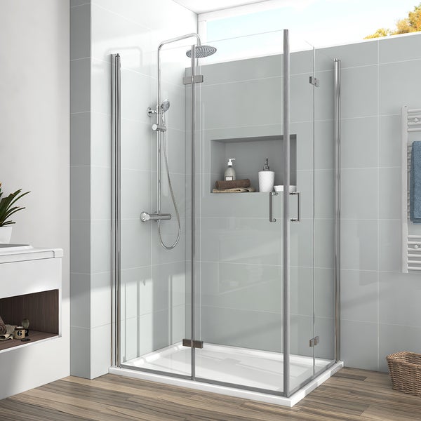 Moderne Eckduschkabine mit transparenten Glaswänden, verchromten Profilen, Regenduschkopf und weißer Duschwanne in einem hellen Badezimmer.
