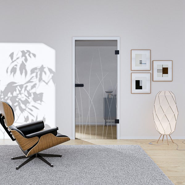 Moderne Ganzglastür mit Gräser-Motiv in einem hellen Wohnzimmer mit Sessel und Stehlampe.