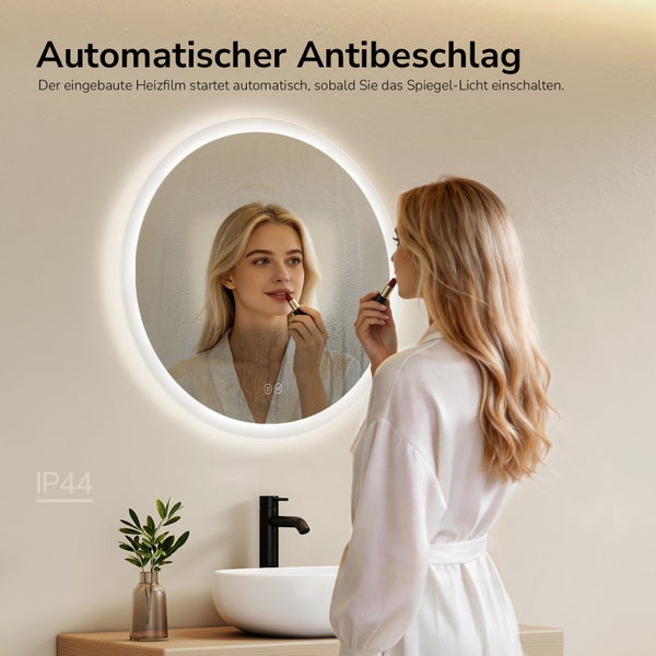 Runder LED-Badezimmerspiegel mit Antibeschlagfunktion zeigt klares Spiegelbild beim Schminken im hellen Bad, spritzwassergeschützt.