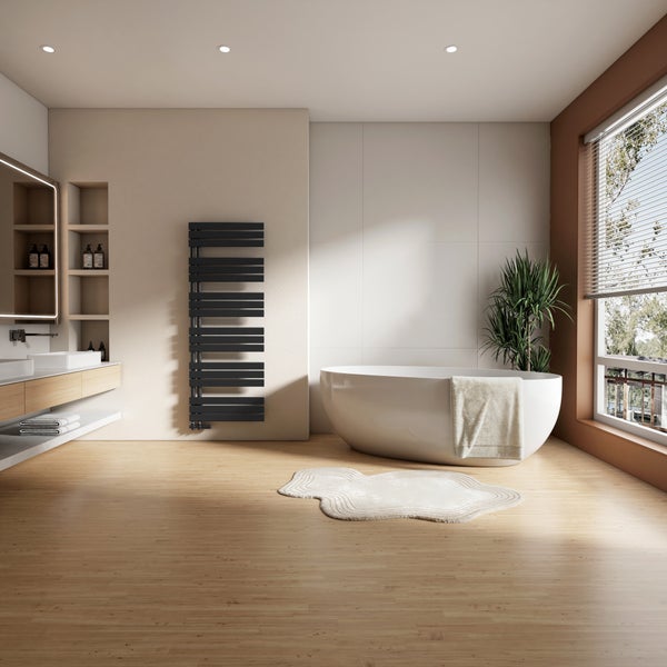 Badezimmer mit Badewanne, Waschtisch, Handtuchwärmer und Holzfußboden für eine helle und freundliche Atmosphäre.