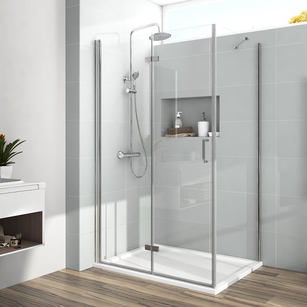 Moderne Duschkabine aus Glas mit flacher Duschwanne, Regenduschkopf und verchromten Armaturen in einem hellen Badezimmer mit grauen Fliesen.