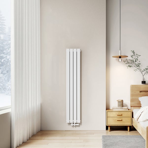 Modernes Schlafzimmer mit senkrechtem Heizkörper, Nachttisch und Fensterblick auf verschneite Bäume.