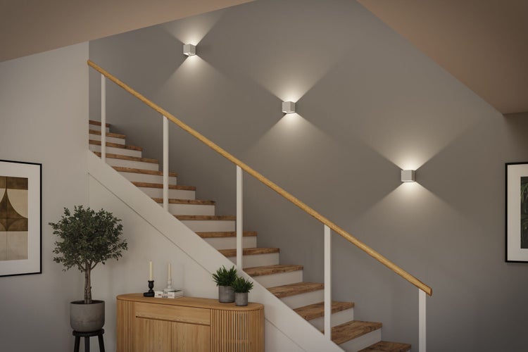 Treppenhaus mit Treppe, Kommode und Wandleuchten