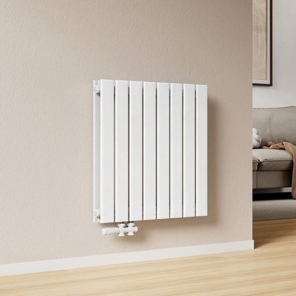 Weißer Flachheizkörper an einer Wohnzimmerwand montiert mit Thermostatkopf für effiziente Heizung im modern eingerichteten Raum.