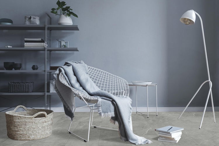 Wohnzimmer mit Regal, Lampe, Korb und Stuhl mit Decke