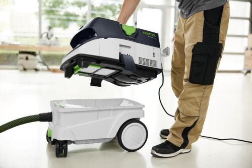 Eine Person hebt das Oberteil eines Festool Absaugmobils von dem fahrbaren Behälter ab.
