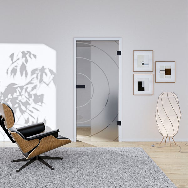 Modernes Wohnzimmer mit einer Ganzglastür mit Kreismuster und schwarzen Beschlägen, Design-Sessel und grauem Teppich in heller Atmosphäre.