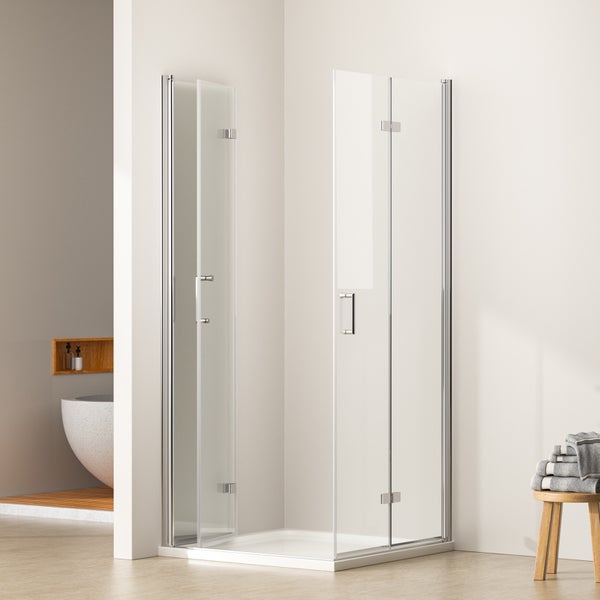 Moderne Duschkabine mit Glas-Falttüren, verchromten Griffen und weißer Duschwanne in einem hellen Badezimmer.