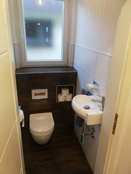 Kompaktes Badezimmer mit Toilette, Waschbecken und Fenster für kleine Räume