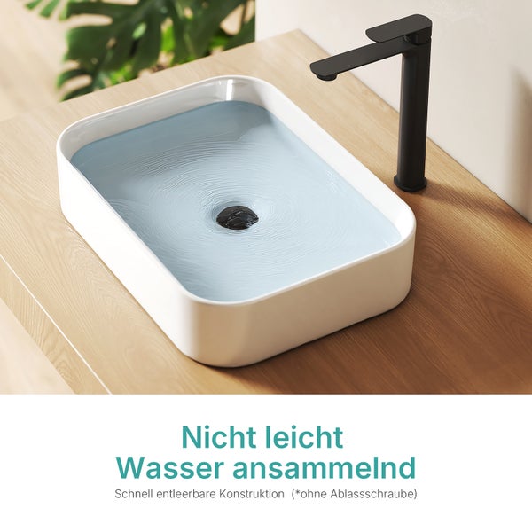 Aufsatzwaschbecken aus Keramik mit schwarzer Armatur auf einer Holzoberfläche