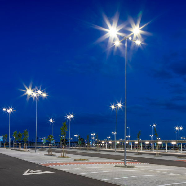 Beleuchteter Parkplatz mit Parkmarkierungen und Beschilderung bei Nacht
