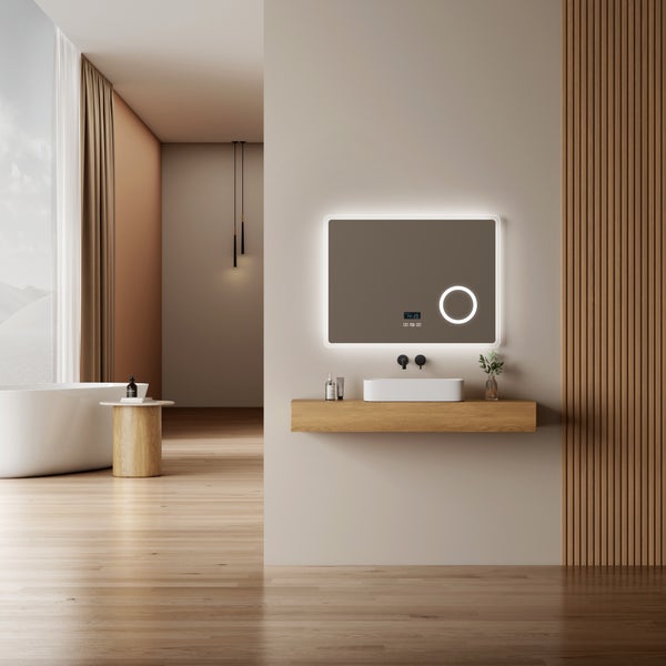 Modernes Badezimmer mit rechteckigem LED-Spiegel inklusive Digitaluhr, weißem Aufsatzwaschbecken auf Holzkonsole und freistehender Badewanne.