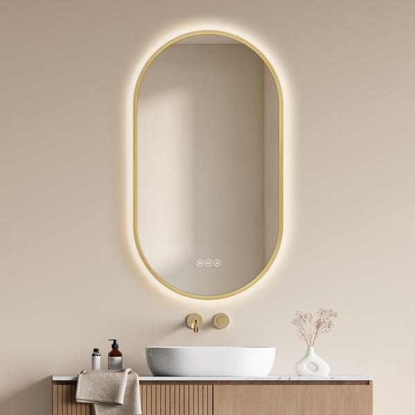 Ovaler Badezimmerspiegel mit LED Beleuchtung und Touch Steuerung über einem Waschbecken auf einem Holzunterschrank.