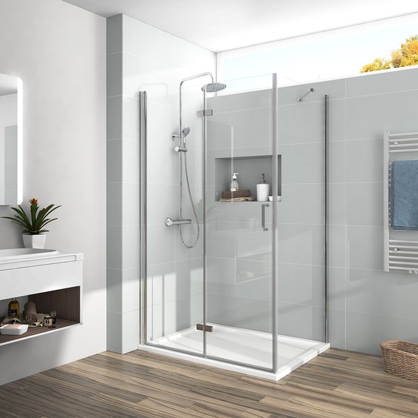 Moderne Duschecke mit Glaswänden, Chromrahmen, Regendusche und flacher Duschwanne in einem hellen Badezimmer mit Fliesen und Holzboden.